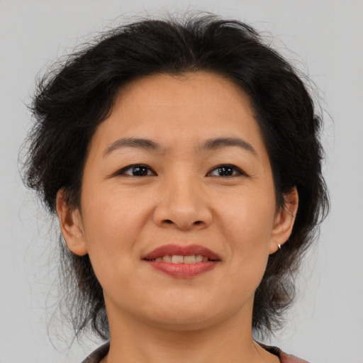 Joyful asian adult female with medium  brown hair and brown eyes