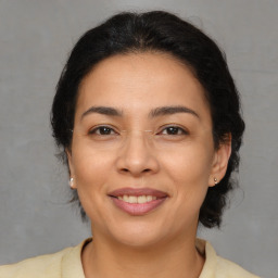 Joyful latino adult female with medium  brown hair and brown eyes