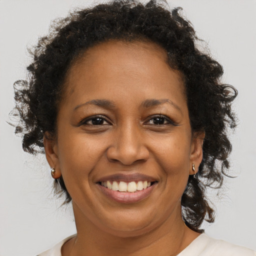 Joyful black adult female with medium  brown hair and brown eyes