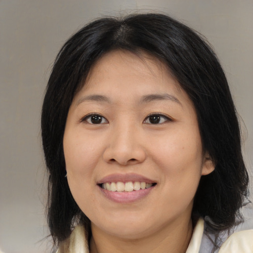 Joyful asian young-adult female with medium  brown hair and brown eyes