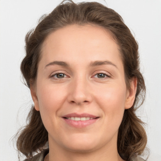 Joyful white young-adult female with medium  brown hair and grey eyes