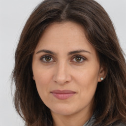 Joyful white adult female with long  brown hair and brown eyes