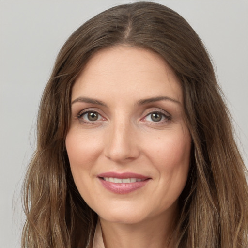 Joyful white young-adult female with long  brown hair and grey eyes