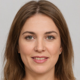 Joyful white young-adult female with long  brown hair and green eyes