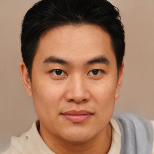 Joyful asian young-adult male with short  brown hair and brown eyes