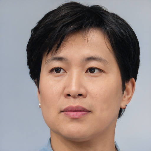 Joyful asian adult male with medium  black hair and brown eyes