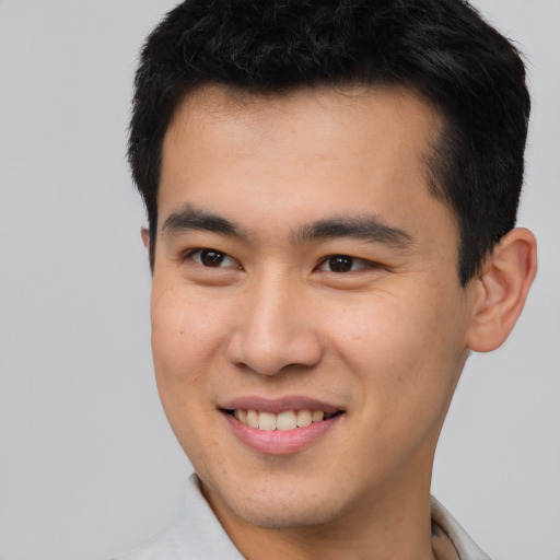 Joyful latino young-adult male with short  brown hair and brown eyes