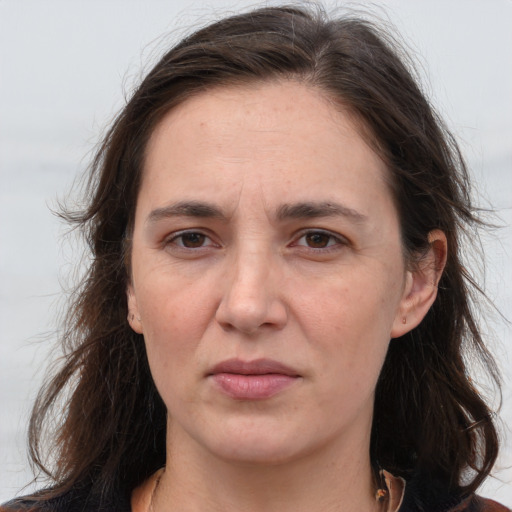 Joyful white adult female with long  brown hair and grey eyes