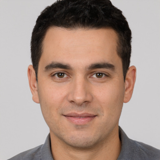 Joyful white young-adult male with short  black hair and brown eyes