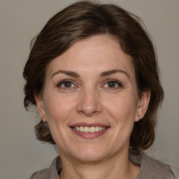 Joyful white adult female with medium  brown hair and grey eyes