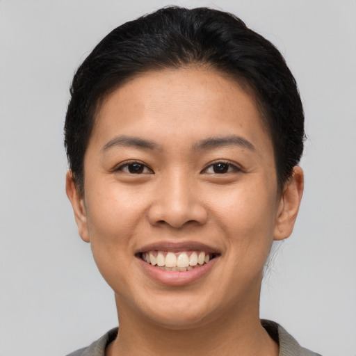 Joyful asian young-adult female with short  brown hair and brown eyes