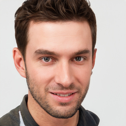 Joyful white young-adult male with short  brown hair and grey eyes