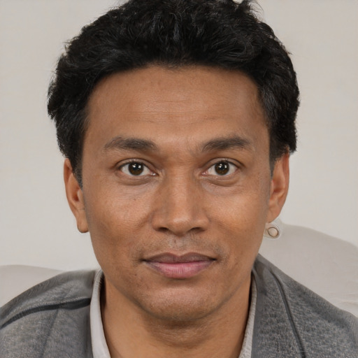 Joyful black adult male with short  black hair and brown eyes