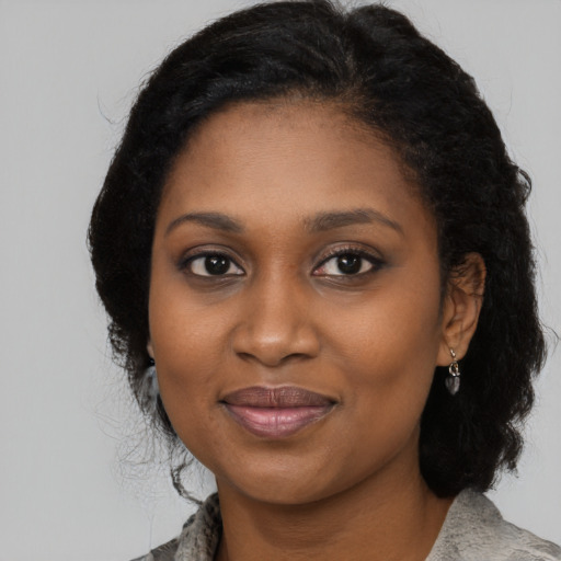 Joyful black young-adult female with medium  black hair and brown eyes