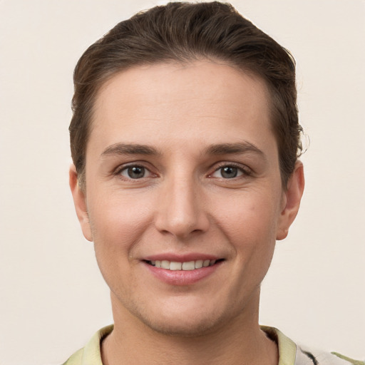 Joyful white young-adult female with short  brown hair and grey eyes