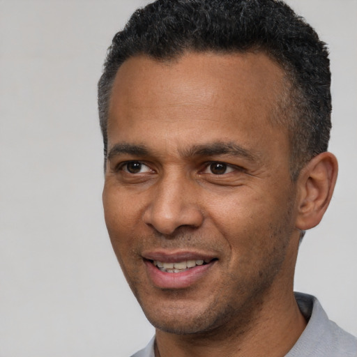 Joyful latino adult male with short  black hair and brown eyes