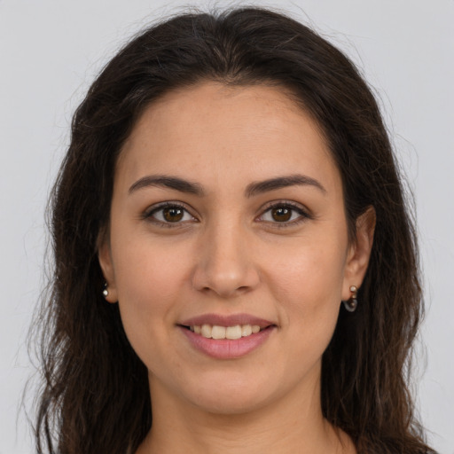 Joyful white young-adult female with long  brown hair and brown eyes