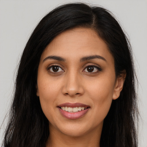 Joyful latino young-adult female with long  brown hair and brown eyes