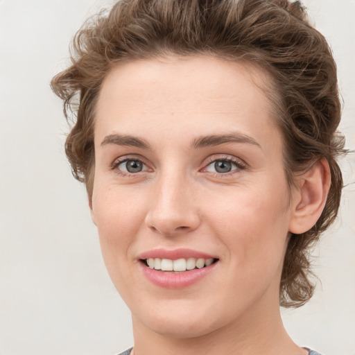 Joyful white young-adult female with medium  brown hair and green eyes