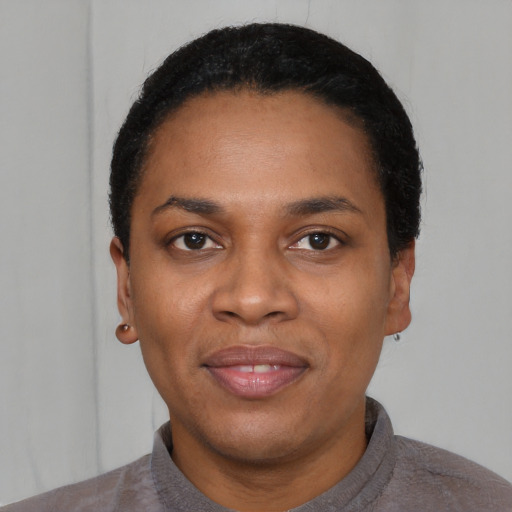 Joyful black young-adult female with short  black hair and brown eyes