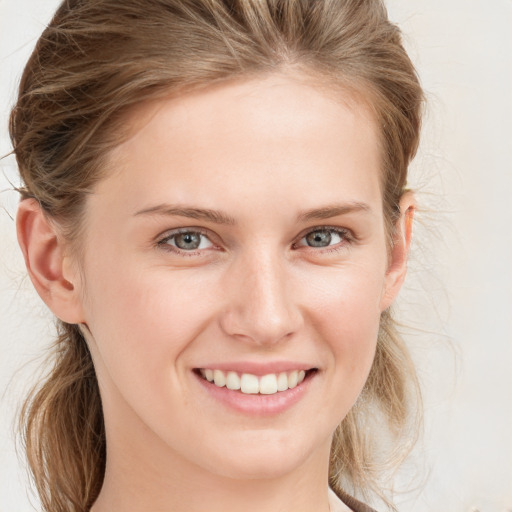 Joyful white young-adult female with medium  brown hair and blue eyes