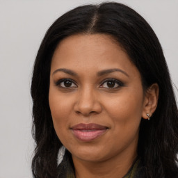 Joyful black young-adult female with long  brown hair and brown eyes