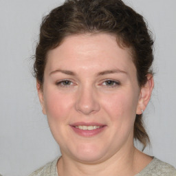 Joyful white young-adult female with medium  brown hair and blue eyes