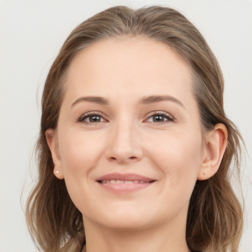 Joyful white young-adult female with medium  brown hair and grey eyes