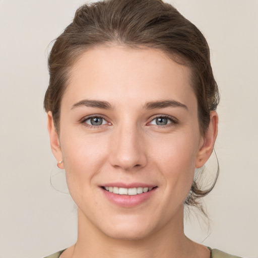 Joyful white young-adult female with medium  brown hair and grey eyes