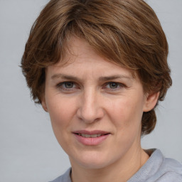 Joyful white adult female with medium  brown hair and grey eyes