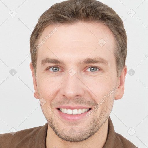 Joyful white young-adult male with short  brown hair and grey eyes