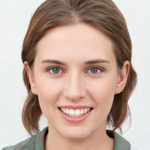 Joyful white young-adult female with medium  brown hair and blue eyes