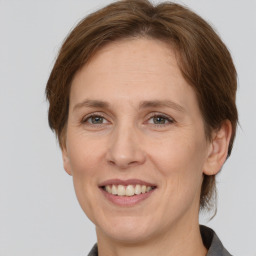 Joyful white adult female with medium  brown hair and grey eyes