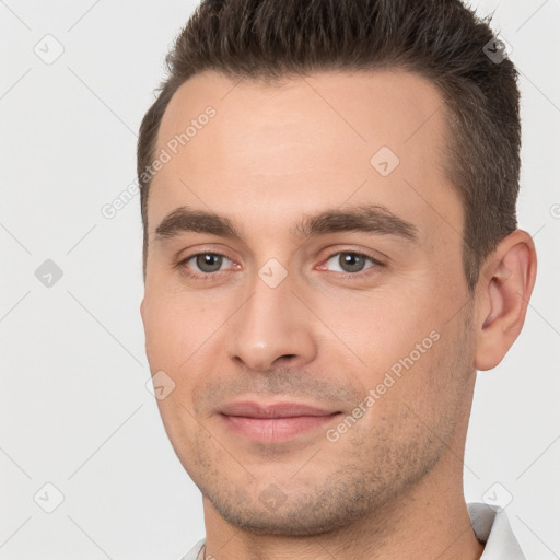 Joyful white young-adult male with short  brown hair and brown eyes