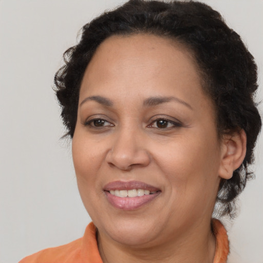 Joyful latino adult female with medium  brown hair and brown eyes