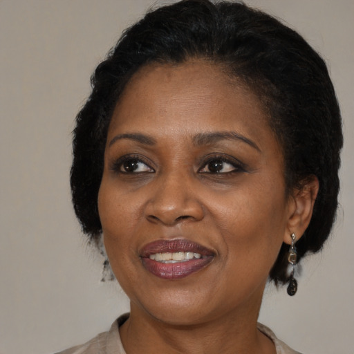 Joyful black adult female with medium  brown hair and brown eyes