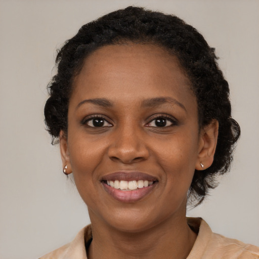 Joyful black young-adult female with medium  black hair and brown eyes