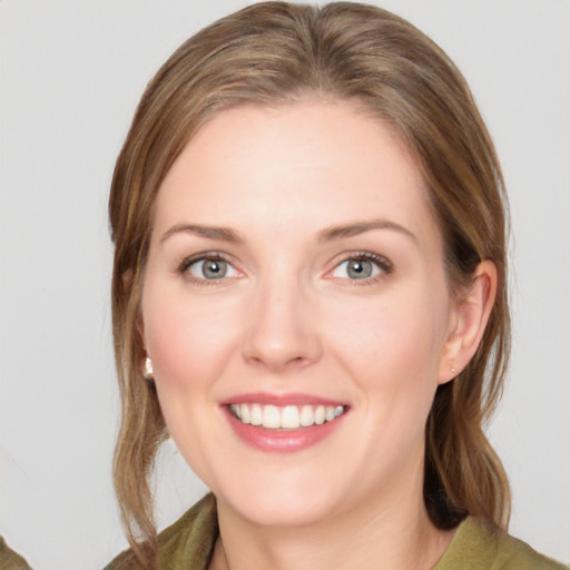 Joyful white young-adult female with medium  brown hair and green eyes