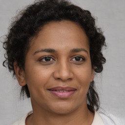 Joyful black adult female with medium  brown hair and brown eyes