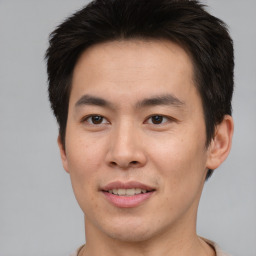 Joyful asian young-adult male with short  brown hair and brown eyes