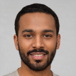 Joyful latino young-adult male with short  black hair and brown eyes