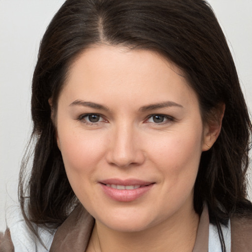 Joyful white young-adult female with long  brown hair and brown eyes