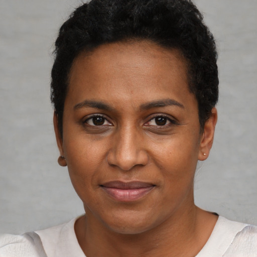Joyful black young-adult female with short  black hair and brown eyes