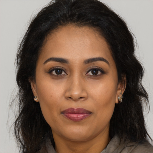 Joyful latino adult female with long  brown hair and brown eyes