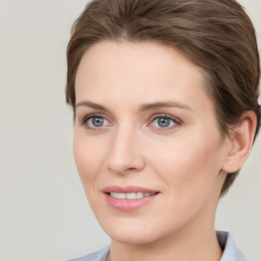 Joyful white young-adult female with short  brown hair and grey eyes