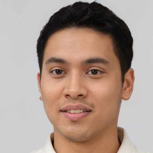 Joyful latino young-adult male with short  black hair and brown eyes