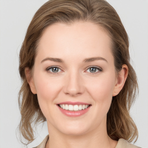 Joyful white young-adult female with medium  brown hair and grey eyes