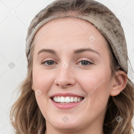 Joyful white young-adult female with long  brown hair and blue eyes