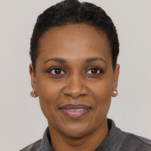 Joyful black adult female with short  black hair and brown eyes