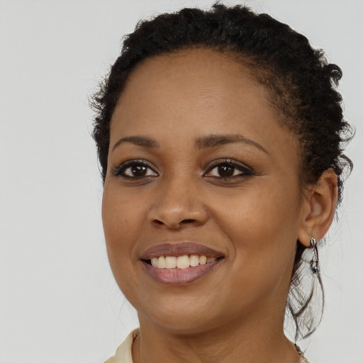 Joyful black young-adult female with long  brown hair and brown eyes